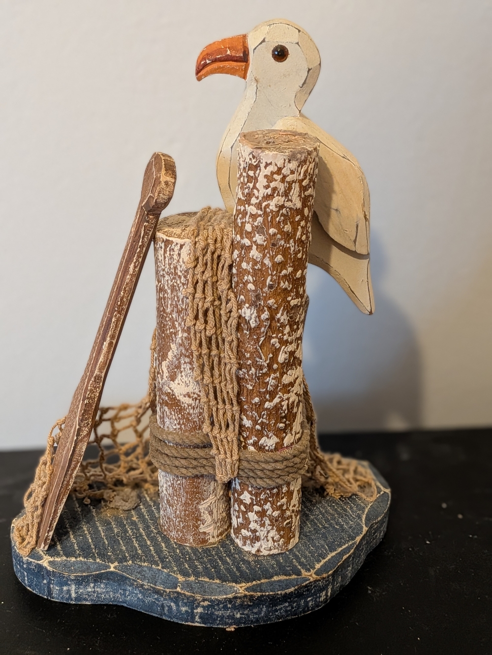 Rustic Wooden Coastal Seagull Figurine Perched On Pier Pilings With Netting